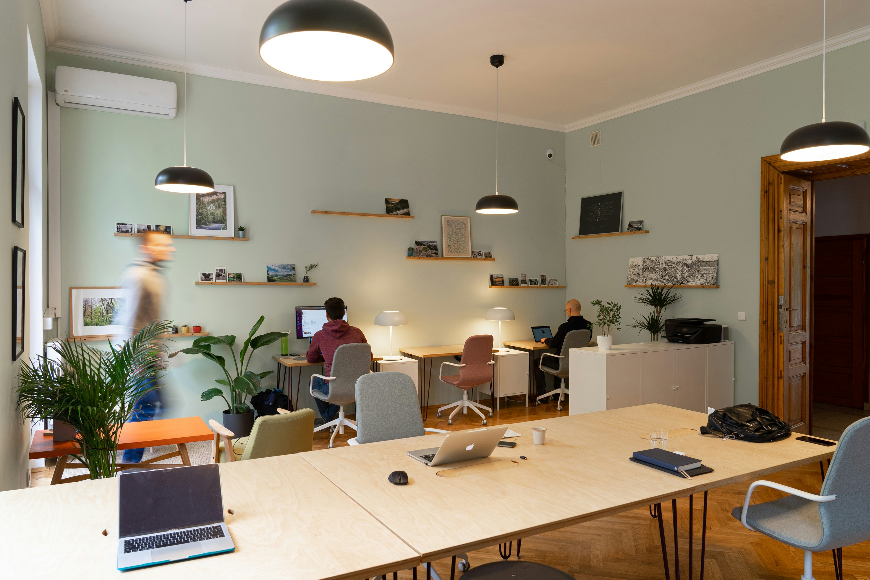 Open coworking office with people moving between desks.