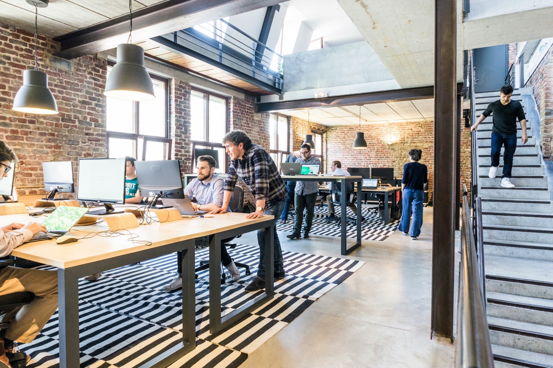 Two colleagues collaborating side-by-side at a workstation.